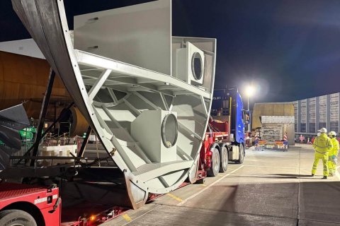 Workers preparing heavy machinery for lifting operation