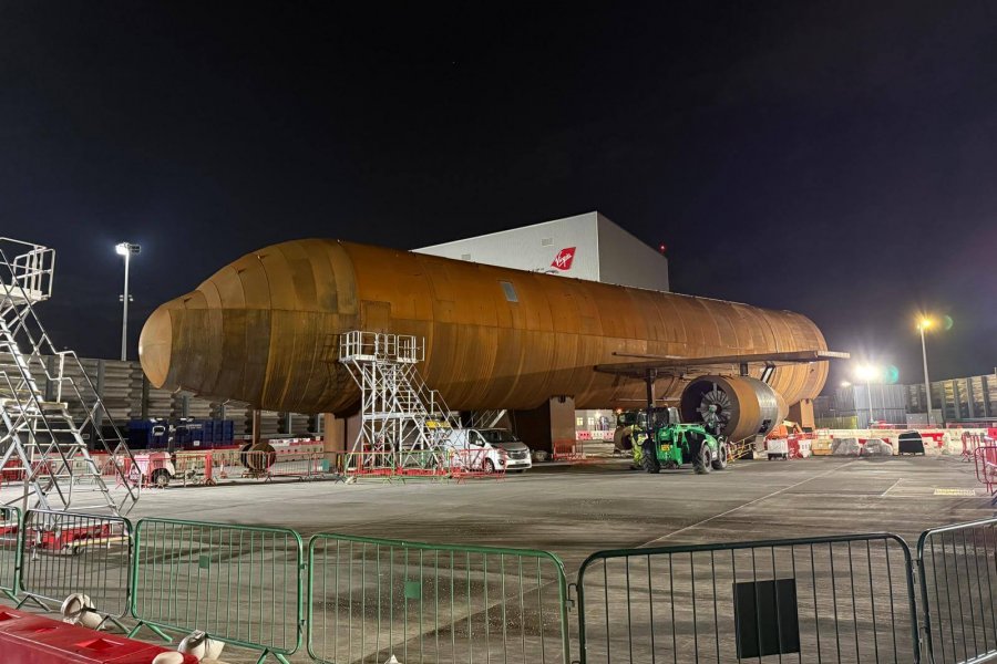 Wide view of storage yard with heavy‑lift trailers and aeroplane equipment